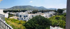 a view of a town with white buildings and mountains at Santanna White Houses in Parikia