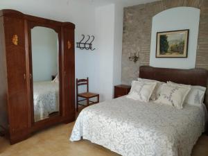 um quarto com uma cama e um espelho em Mas Horta Prim em Sant Pere Pescador
