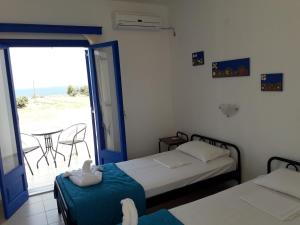 a bedroom with two beds and a balcony with the ocean at Vigles in Adamantas