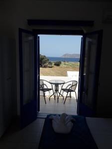 a door leading to a patio with a table and chairs at Vigles in Adamantas