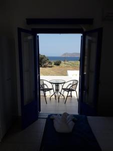 a room with a door open to a patio with a table at Vigles in Adamantas