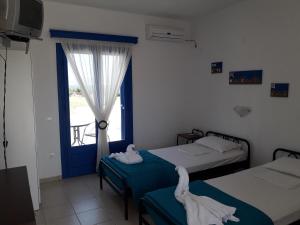 two beds in a room with a window at Vigles in Adamantas