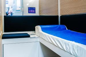 Habitación con cama con manta azul en Resting Pods - ZzzleepandGo VRN Verona Airport, en Caselle di Sommacampagna