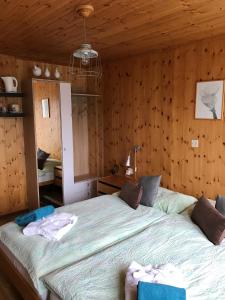 ein Schlafzimmer mit einem großen Bett in einem Zimmer mit Holzwänden in der Unterkunft Hotel Restaurant Emshorn in Oberems