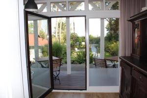 una puerta de cristal que da a un patio con terraza en Villa Waldheim - WG 3, en Boltenhagen 1 foto más