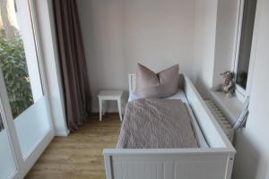 een kamer met een bed met een kussen en een raam bij Villa Waldheim - WG 3 in Boltenhagen