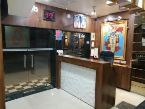 a glass display case in a room with a checkered floor at Hotel Milan in Dwarka