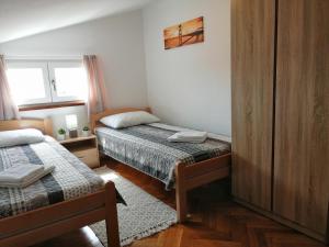 - une petite chambre avec 2 lits et une fenêtre dans l'établissement Santa Marina, à Vabriga