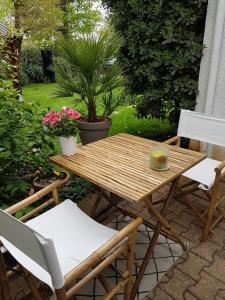 einen Holztisch und Stühle auf einer Terrasse in der Unterkunft Chambre Indépendante "Terre Rouge" in Martignas-sur-Jalle