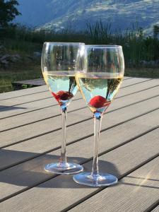 dos copas de vino sentadas sobre una mesa de madera en Hotel Restaurant Emshorn, en Oberems
