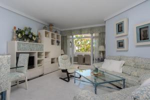 sala de estar con sofá y mesa de cristal en Marbella Real 421, en Marbella