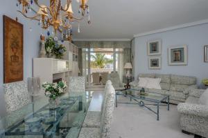 sala de estar con mesa de cristal y lámpara de araña en Marbella Real 421, en Marbella