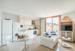 eine Küche und ein Wohnzimmer mit einem Tisch und einem Sofa in der Unterkunft Lets Holidays Estrella Pelegri 2 in Tossa de Mar