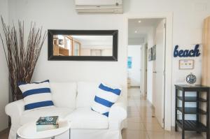 a white living room with a white couch and a mirror at Lets Holidays Estrella Pelegri 2 in Tossa de Mar