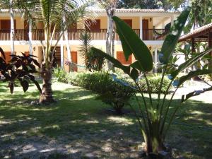 un patio con palmeras y un edificio en Pousada Namuncurá, en Arraial d'Ajuda