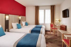 ein Hotelzimmer mit zwei Betten und einem Schreibtisch in der Unterkunft Hôtel Roissy in Lourdes + 83 Fotos