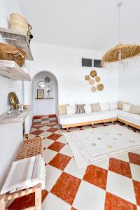 a living room with a couch and a checkerboard floor at Surf And Soul Morocco in Oualidia
