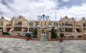a large building with a courtyard in front of it at Yucca Park ApartHotel in Adeje