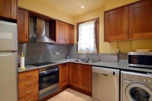 a kitchen with wooden cabinets and a washer and dryer at Vacaciones Tossa de Mar in Tossa de Mar +36 photos