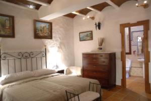 ein Schlafzimmer mit einem Bett und ein Badezimmer mit einem Waschbecken in der Unterkunft Guadalete in Grazalema