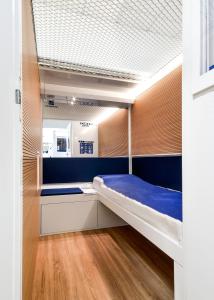 Schlafzimmer mit Etagenbett und blauen Wänden in der Unterkunft Resting Pods - ZzzleepandGo VRN Verona Airport in Caselle di Sommacampagna