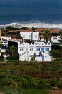 a white house on a hill next to the ocean at Surf And Soul Morocco in Oualidia