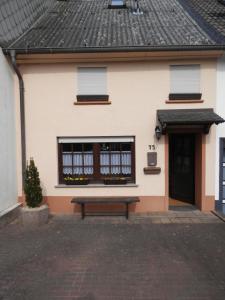 uma casa com um banco à frente em Ferienhaus Greta em Malborn