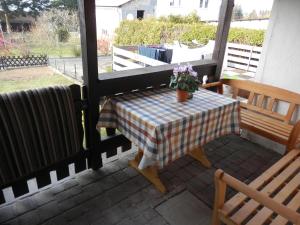 a table and bench on a patio with a table and flowers at Ferienhaus Greta in Malborn