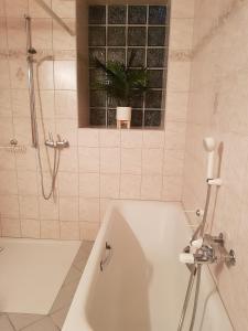 La salle de bains est pourvue d'une baignoire blanche et d'une fenêtre. dans l'établissement Apartement-Gîte rural à 3 km de Delémont, à Courcelon