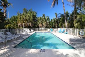 a swimming pool with chairs and a fence at Grove City Motel in Englewood