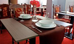 a wooden table with plates and wine glasses on it at Pałac Morski in Gąski