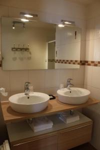 a bathroom with two sinks and a mirror at Logis Le Quai Fleuri in Voves