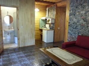 a living room with a red couch and a kitchen at Vila Aura in Šventoji +74 photos