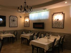 une salle à manger avec des tables et des chaises ainsi qu'un lustre dans l'établissement Guest House Veronika, à Kočevje