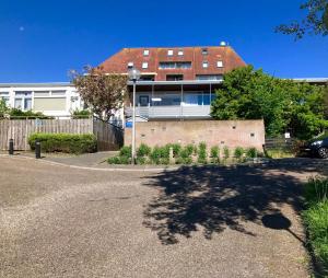 um edifício com uma grande sombra na rua em Reumann Holiday Apartments: De Schelp em Zandvoort