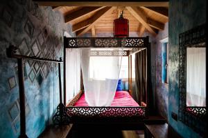 - une chambre avec un lit à baldaquin et une fenêtre dans l'établissement Villa Vietnamonamour, à Milan