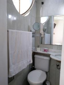 a bathroom with a toilet and a sink and a mirror at Suíte da Fran - Perto da UFF in Niterói
