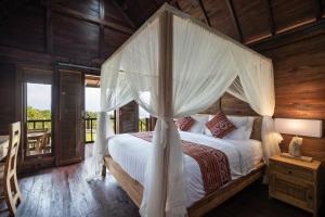 a bedroom with a bed with a canopy at Star Semabu Resort in Nusa Penida
