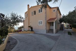 a large house with a driveway in front of it at Apartment Gojak Mišo Alen in Makarska