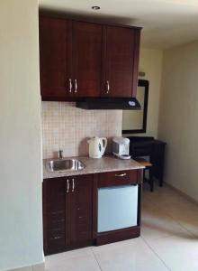 a kitchen with wooden cabinets and a sink at 24 Seven Boutique Hotel in Malia