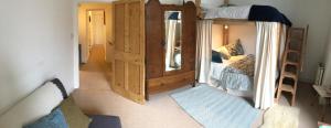 a bedroom with a bunk bed with a mirror at Swan Landing in Chagford
