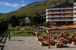 un hotel con mesas y sillas y un edificio en Hotel Montarto, en Baqueira Beret