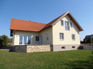 a house with a stone wall and a roof at Ferienwohnung am Kirchberg in Jois