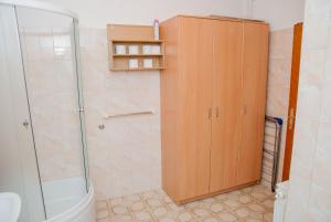 La salle de bains est pourvue d'une douche et d'une armoire en bois. dans l'établissement Apartment Slobo, à Trebinje 12 autres photos
