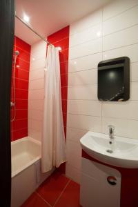 La salle de bains est pourvue d'un lavabo et d'une télévision murale. dans l'établissement Staroievreiska Apartments, à Lviv