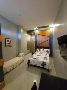 a bedroom with two beds and a couch at Felicidad Resto and Pension House in General Santos
