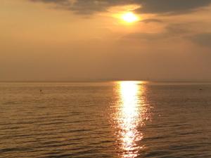 帕莫瑞的住宿－Виктория，太阳落在海洋上的图像