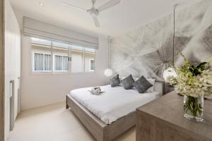 a bedroom with a bed and a vase of flowers at BEACHSIDE VILLA plus APARTMENT - AVA - at SUNSET COVE LUXURY VILLAS, 5 BED 5 BATH, Amazing SEA and MOUNTAIN VIEWS, only 100m walk to Swimming Beach in Bang Rak Beach +37 photos