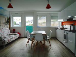 une cuisine et une salle à manger avec une table et des chaises dans l'établissement Residence du Fou, à Trévou-Tréguignec 58 autres photos