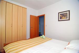 ein Schlafzimmer mit einem Bett mit einem Teddybär drauf in der Unterkunft Apartman Luca in Zečevo